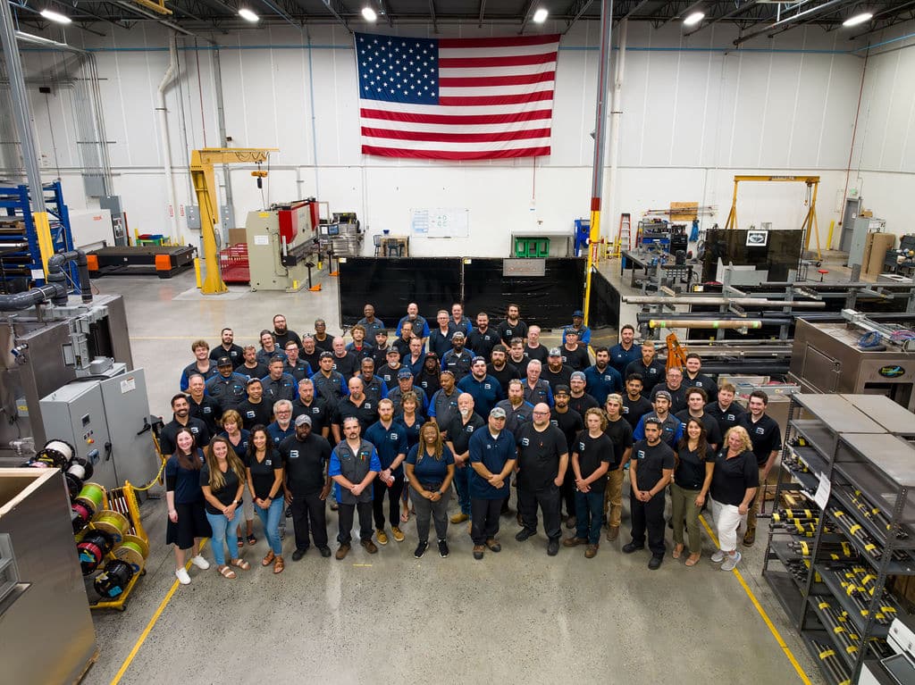 Better Engineering Employees Stand For Group Photo in Front of American Flag