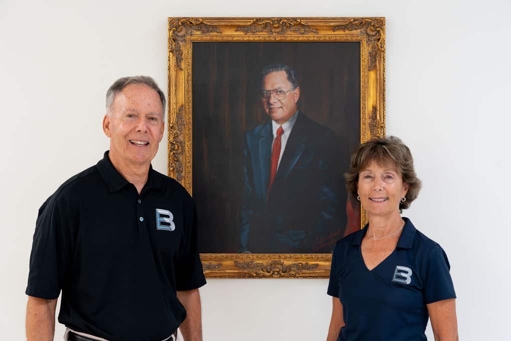 Keith Hiss and Denise Hussar pictured in front of portrait of Bill Hiss